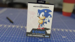 Caja de Sonic the Hedgehog para SEGA Mega Drive sobre una mesa azul con diseño cuadriculado.
